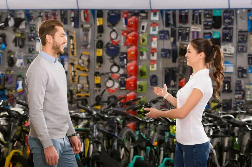 A man and woman talking in a bicycle shop.