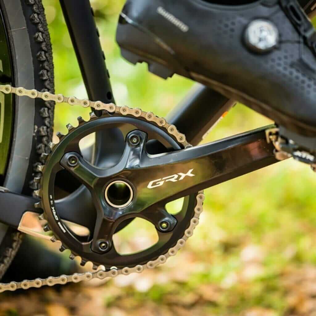 A close up of a bike chain and shoes.