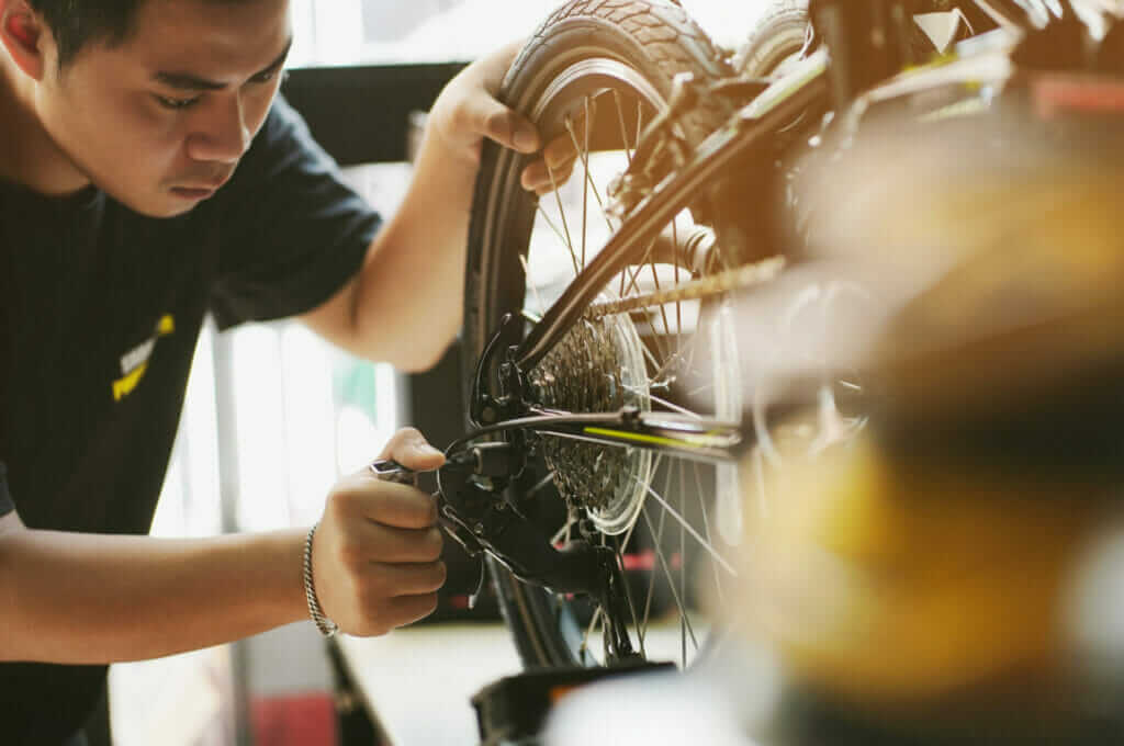 A man working on a bicycle in a shop.