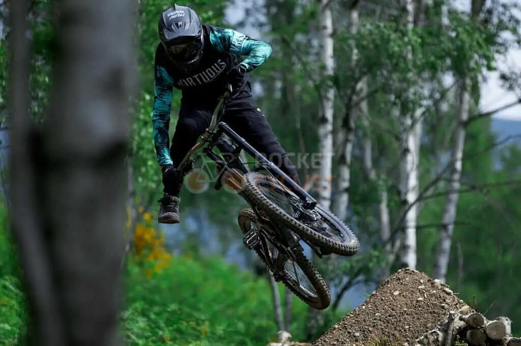 A person riding a mountain bike in the woods.