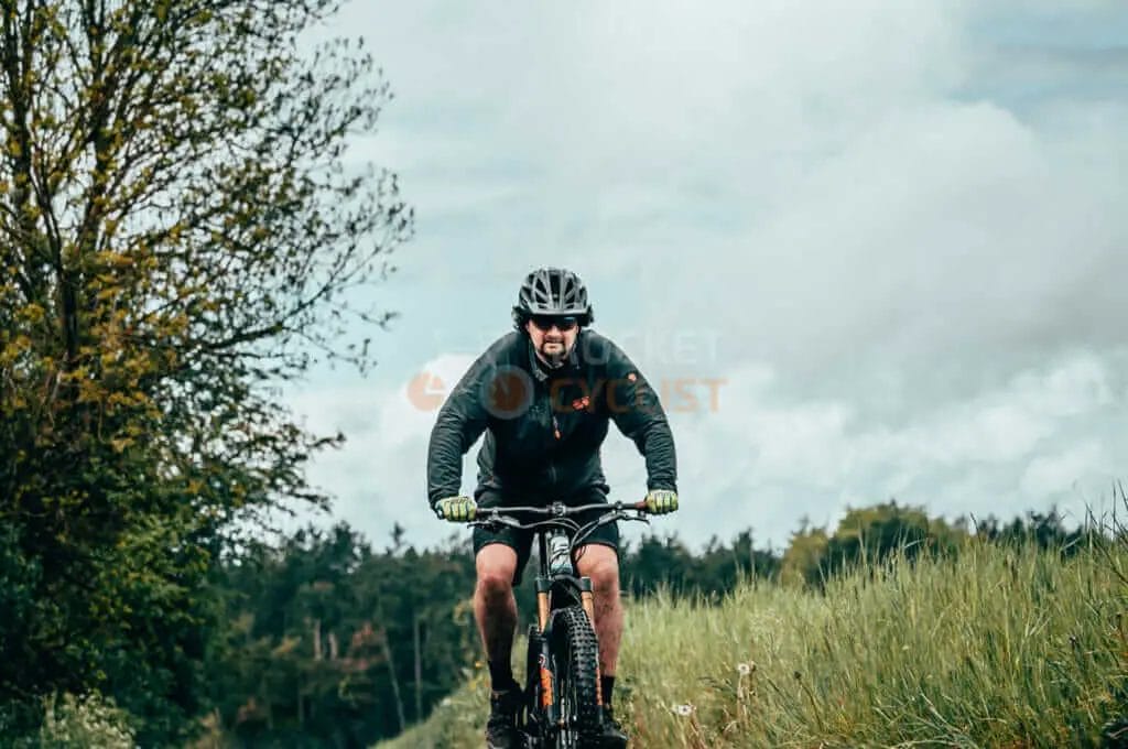 A man riding a mountain bike through a field.