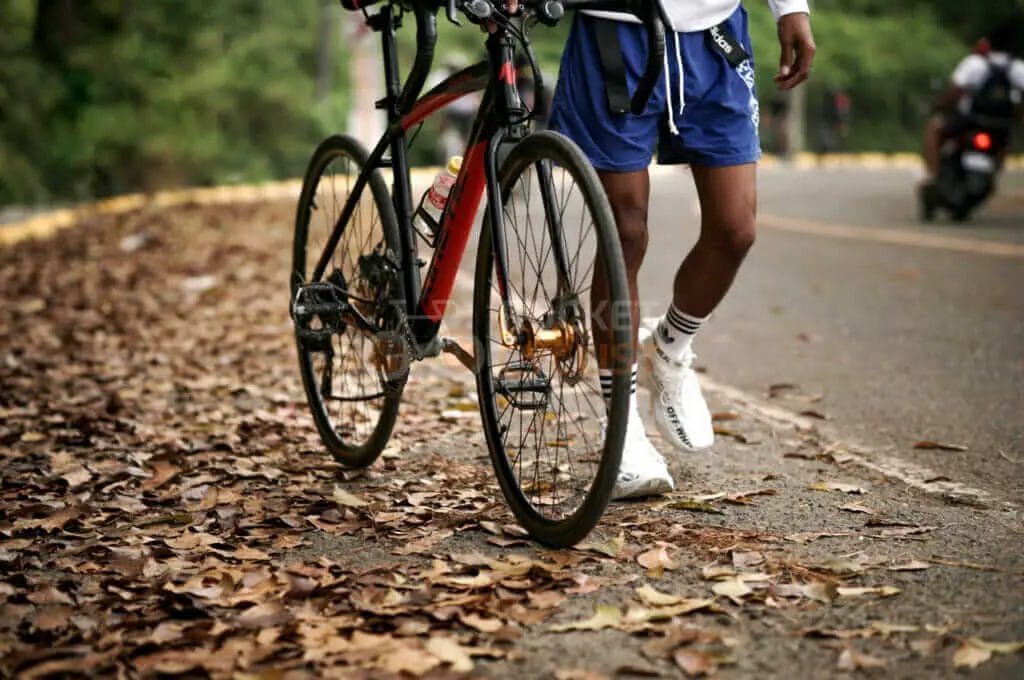 A man with a bike on the road.