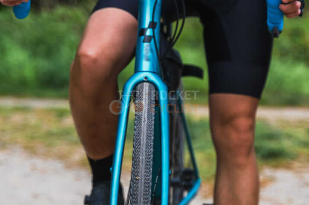 A person riding a blue bike on a dirt road.