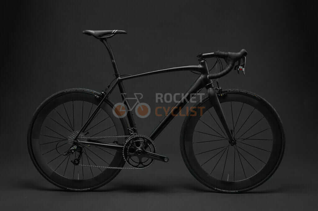 A black bicycle is shown against a black background.