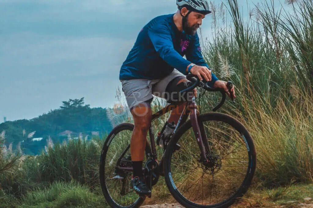 A man riding a bike on a dirt road.