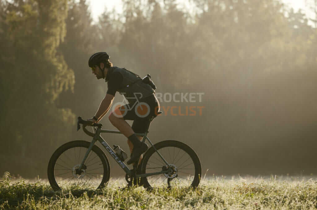 A man riding a bike in a foggy field.