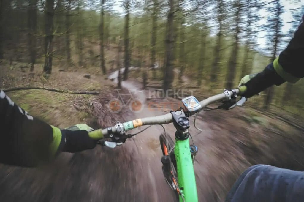 A person riding a mountain bike in the woods.
