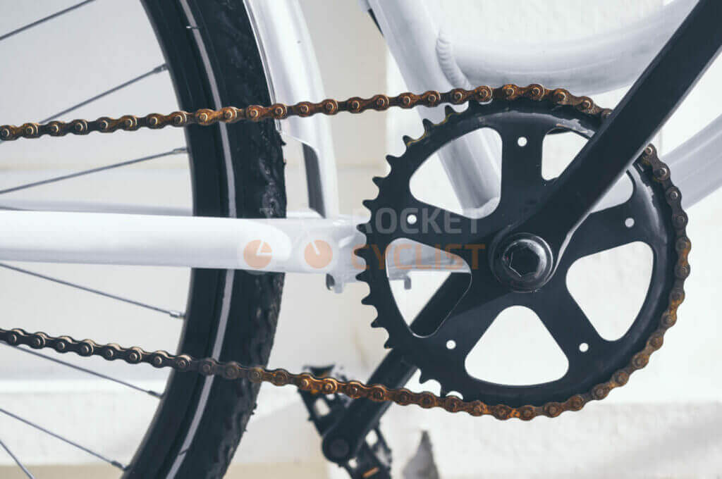Close-up of a bicycle's chain and gear system against a white background.