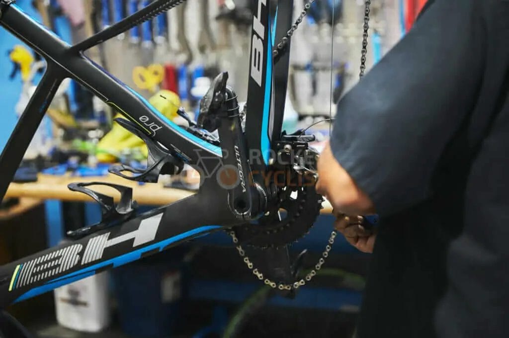 A man is working on a bicycle in a bike shop.