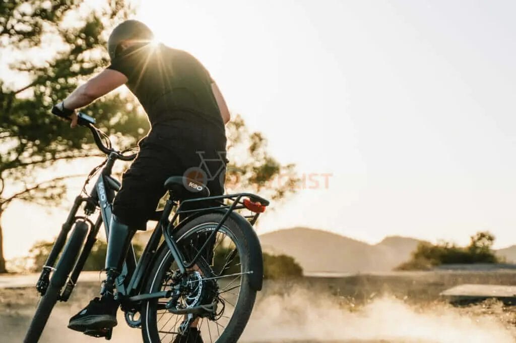 A man riding a bicycle on a dirt road.