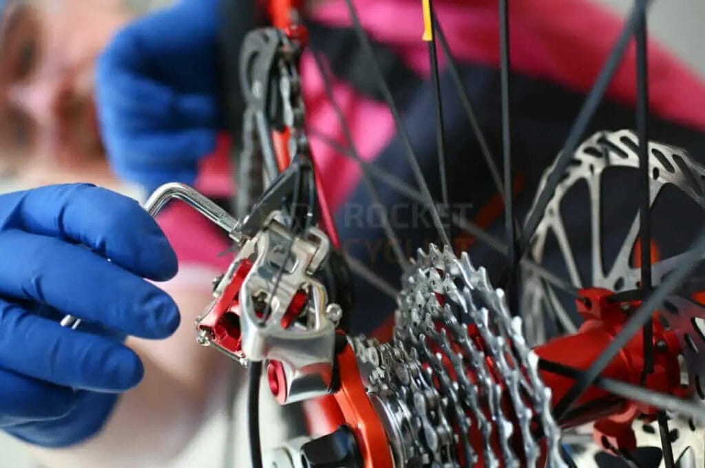 A bicycle mechanic is working on a bicycle wheel.