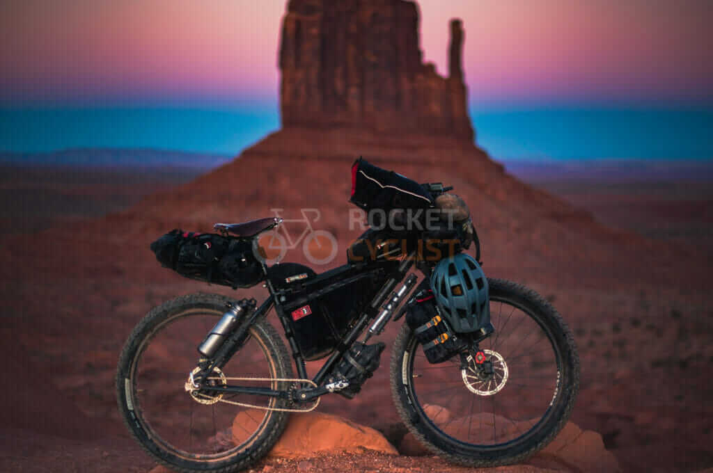 A mountain bike is parked in front of a rock formation.