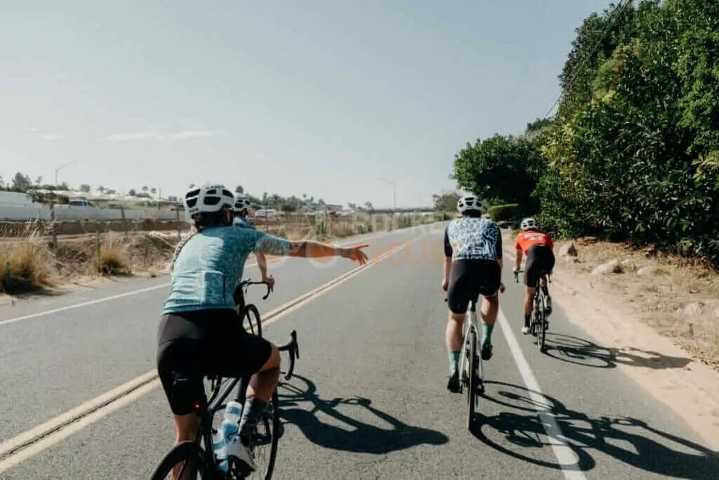 A group of cyclists riding down a road.