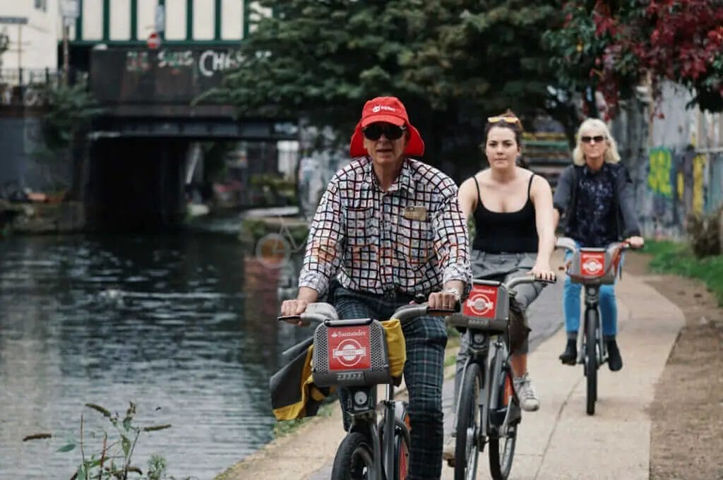A group of people riding bicycles along a canal.
