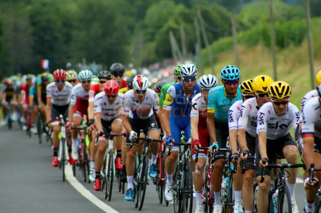 A group of cyclists riding on a road.