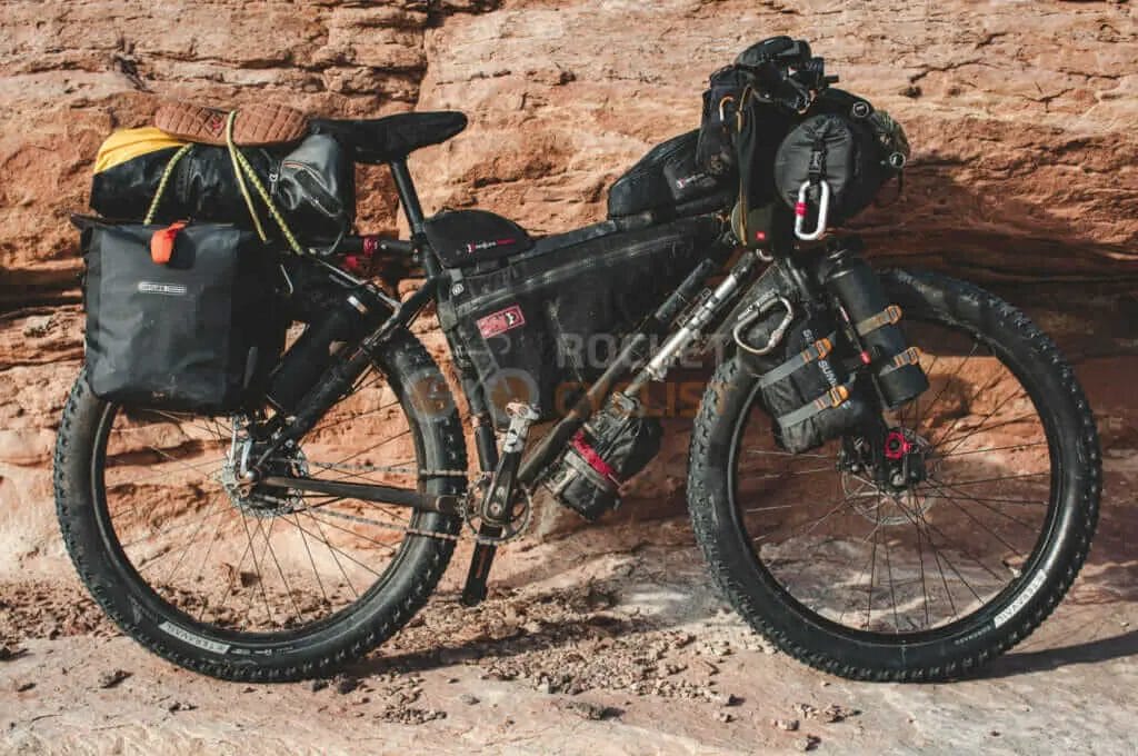 A mountain bike is parked next to a rocky cliff.