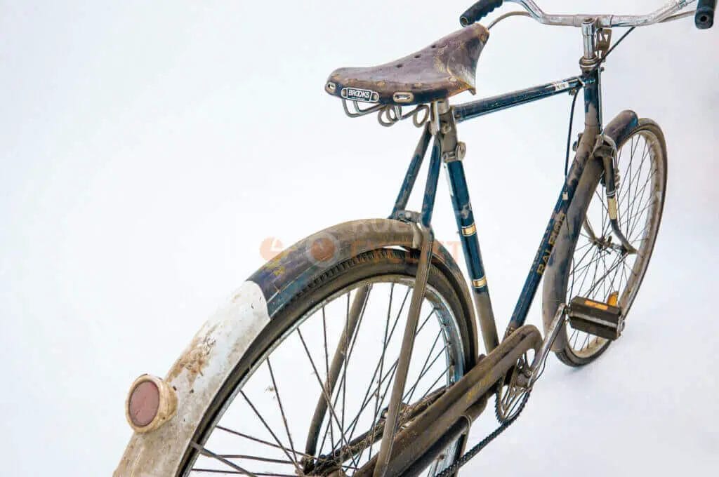 A bicycle is parked in front of a white background.