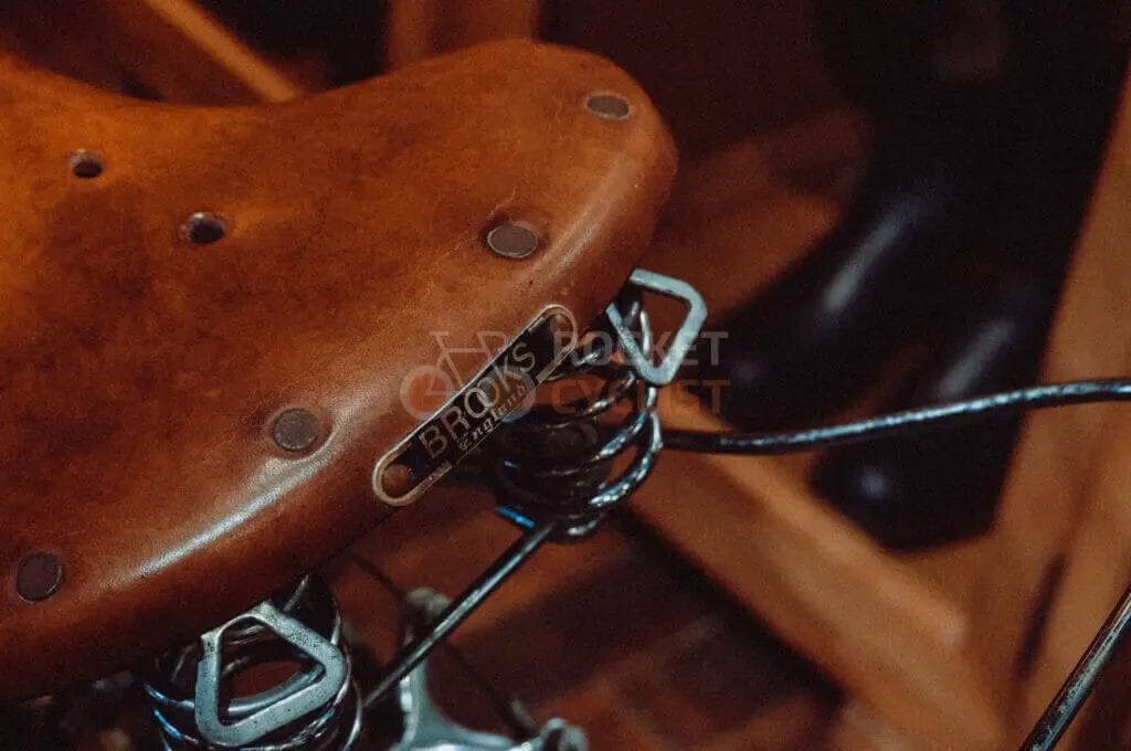 A close up of a leather saddle on a bike.
