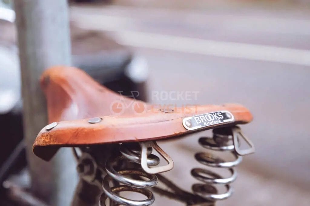 A bicycle seat with springs attached to a pole.