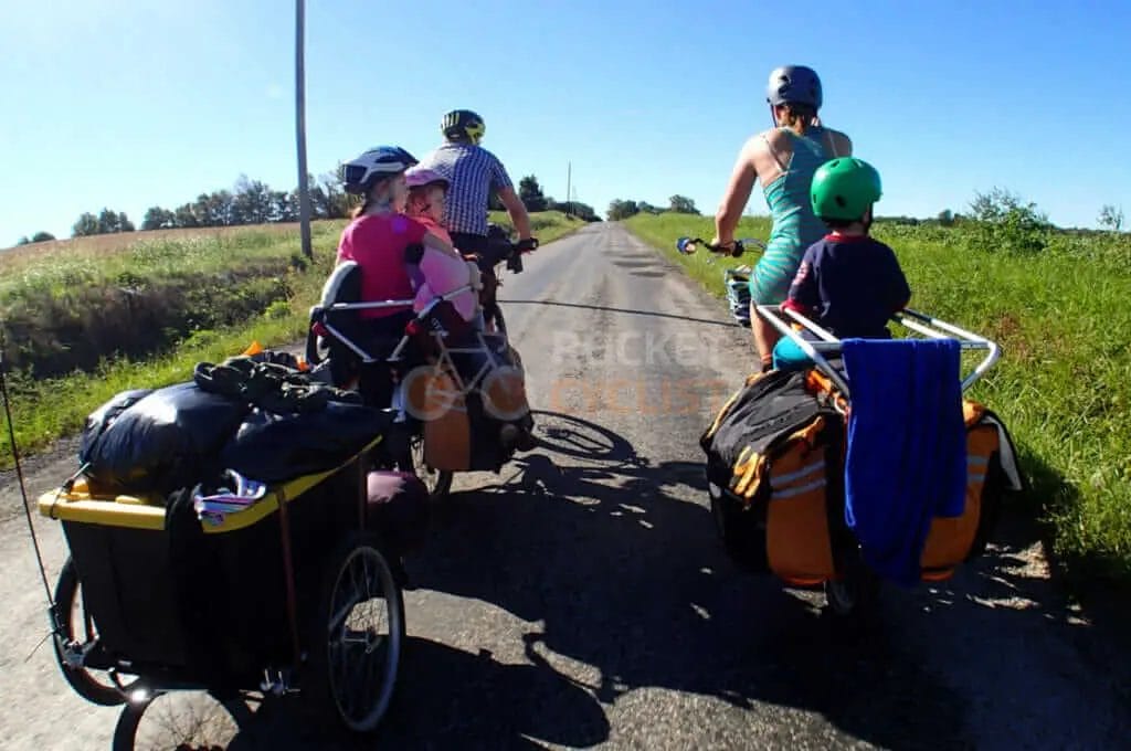 A group of people riding bikes down a country road.