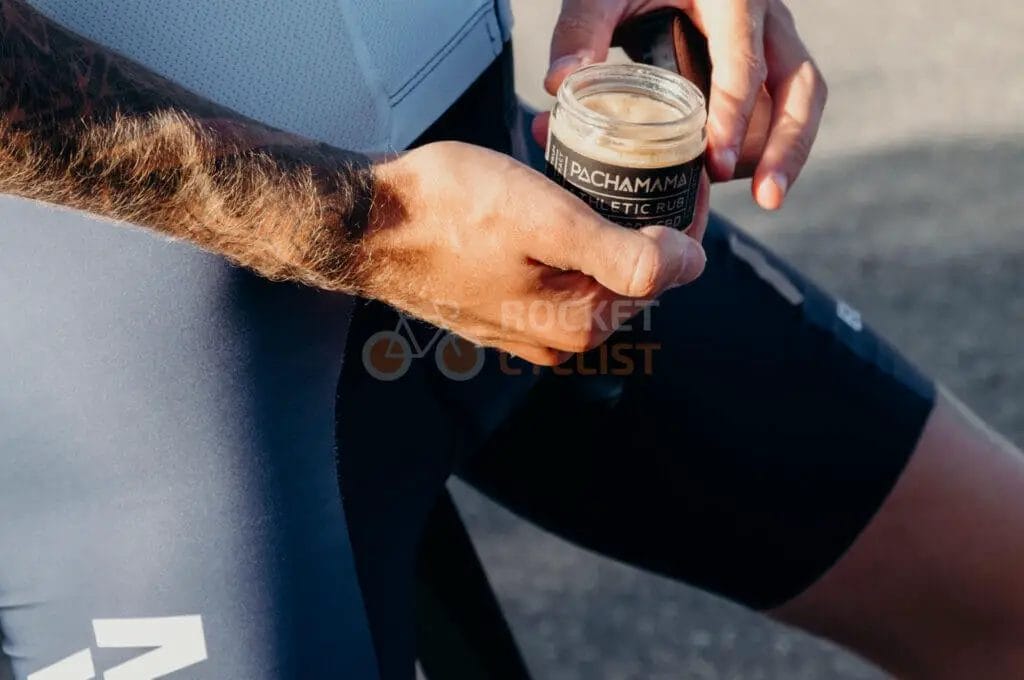 A cyclist holding a cup of coffee.
