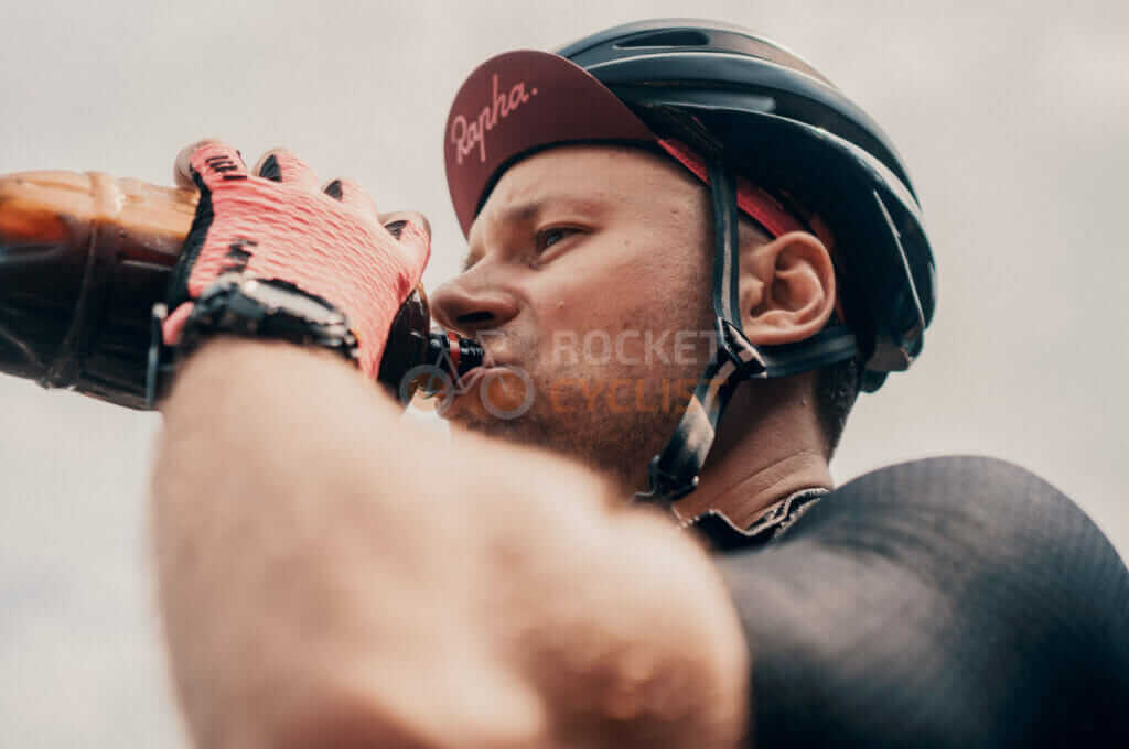 A cyclist drinking from a bottle.
