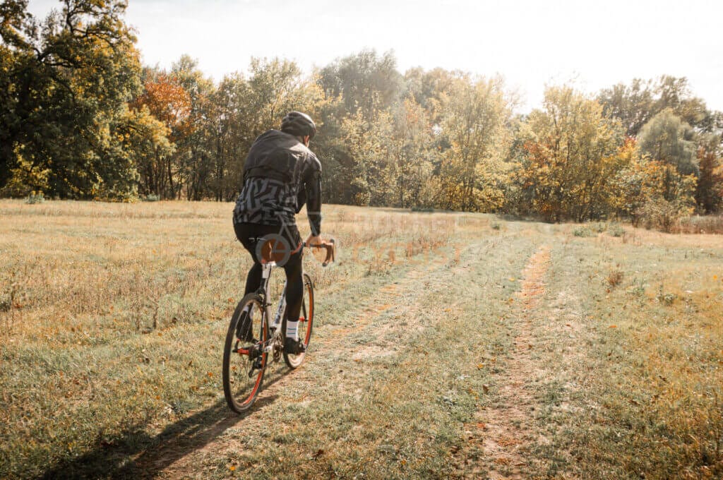 A person riding a bike through a field.