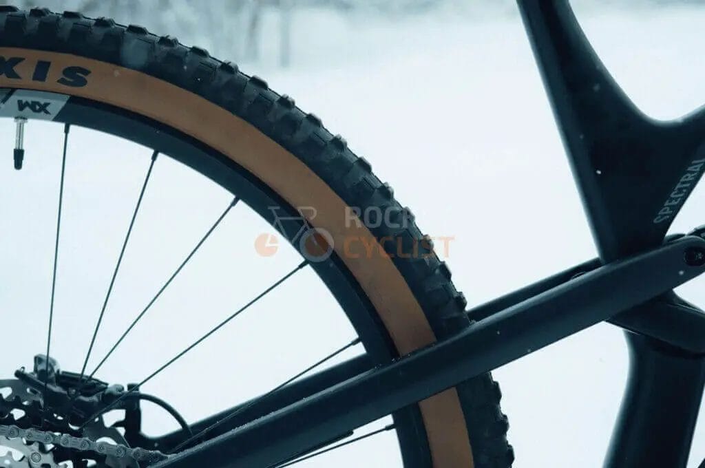 A close up of a mountain bike tire in the snow.