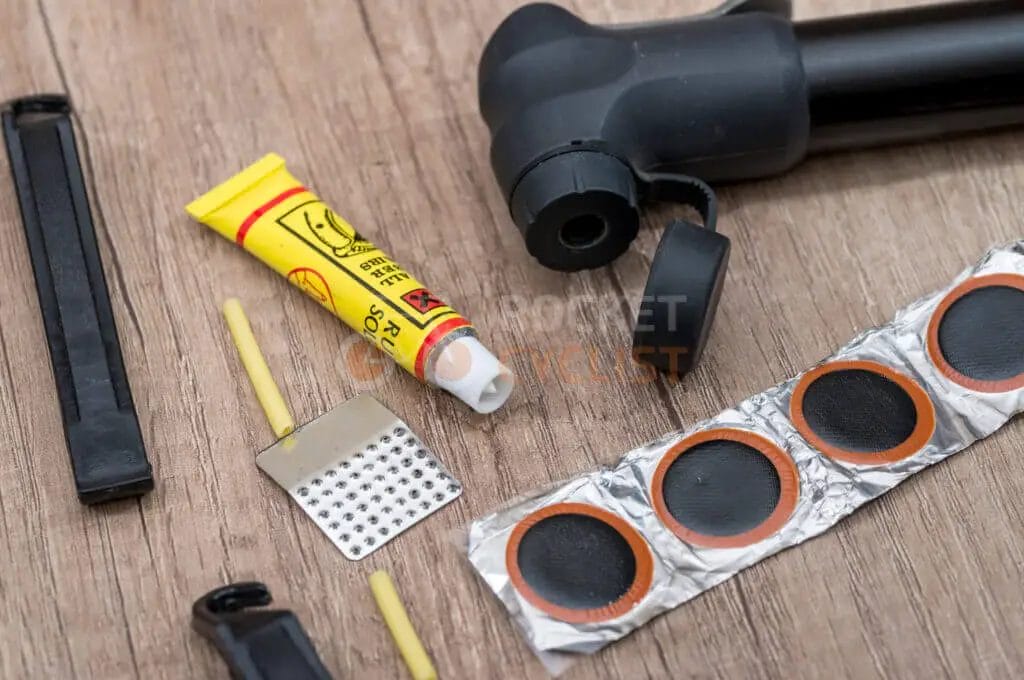 A bicycle repair kit with various tools on a wooden table.