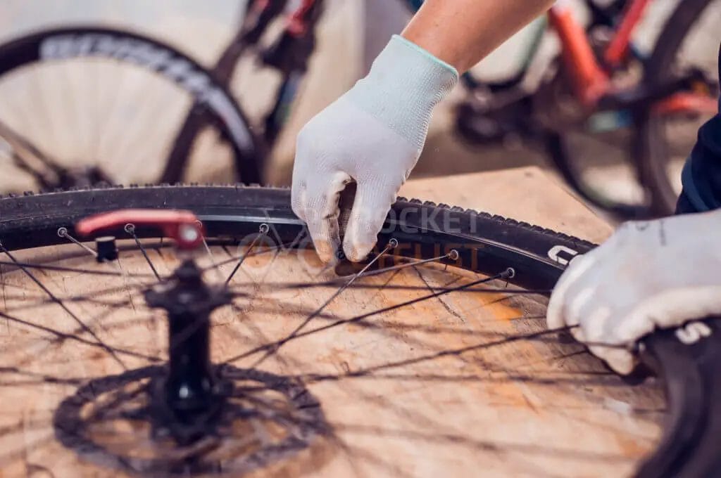 A person is putting a tire on a bicycle.