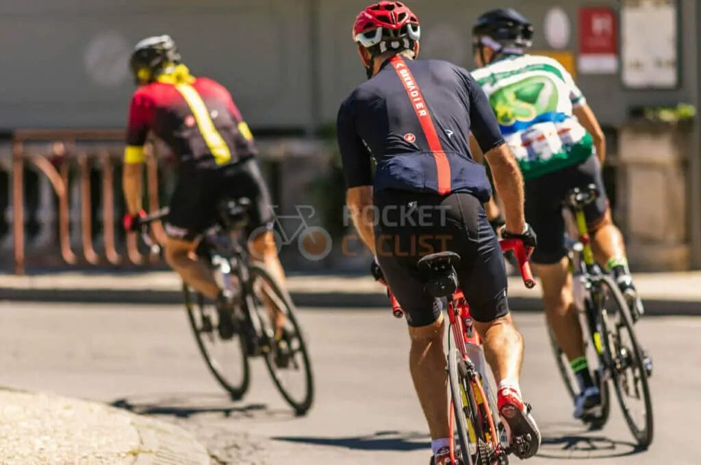 A group of cyclists riding down a street.