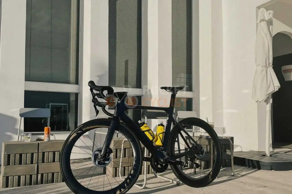 A black bicycle is parked in front of a building.