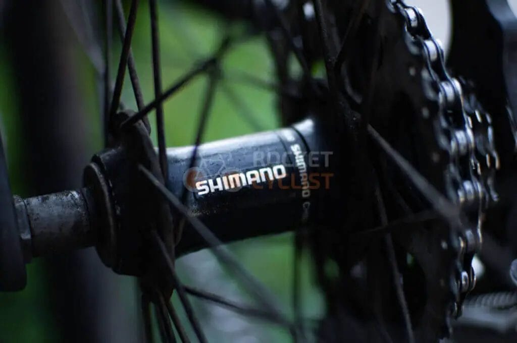 A close up of a bicycle wheel with a chain on it.