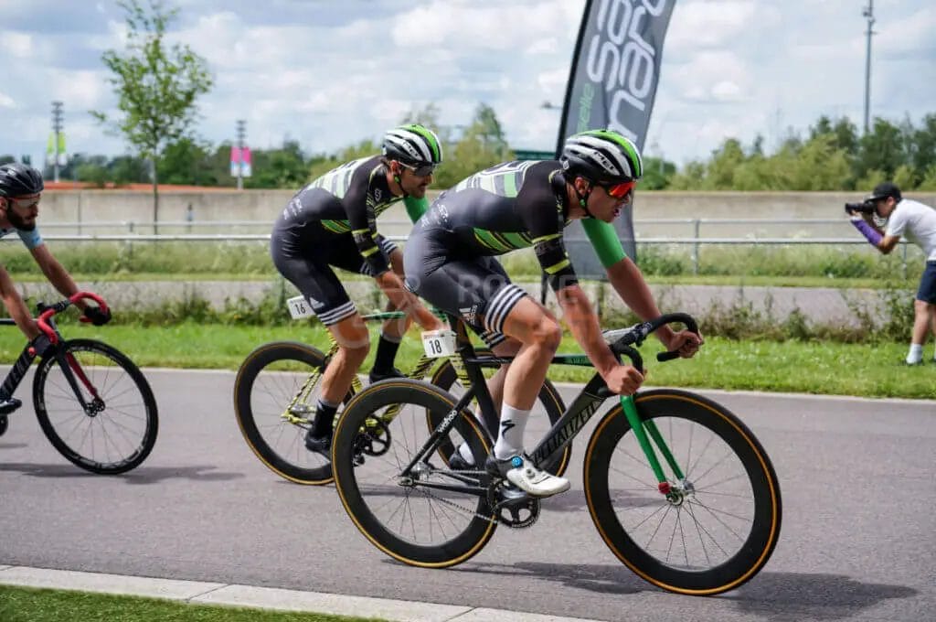 A group of cyclists riding bikes on a road.
