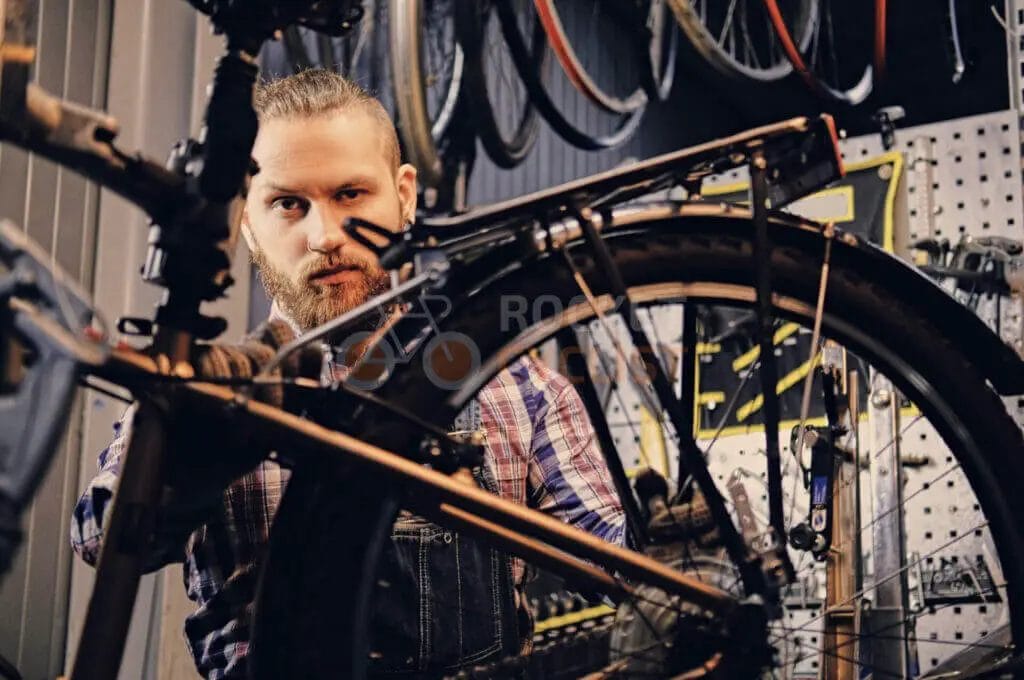 A man working on a bicycle in a workshop.