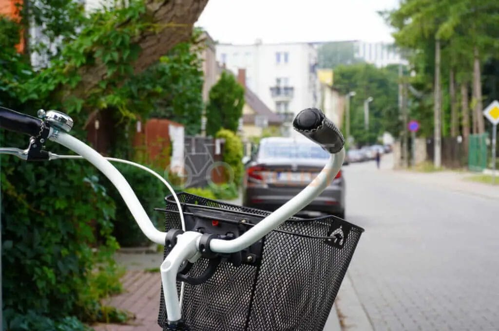 A bicycle is parked on a street next to a tree.