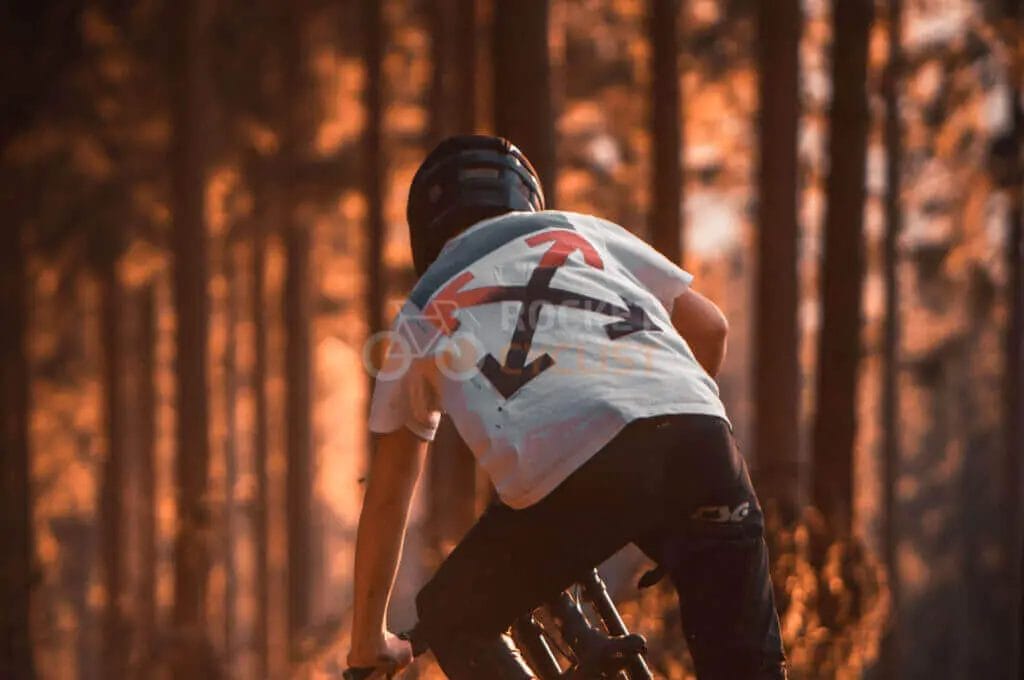 A man riding a mountain bike through a forest.