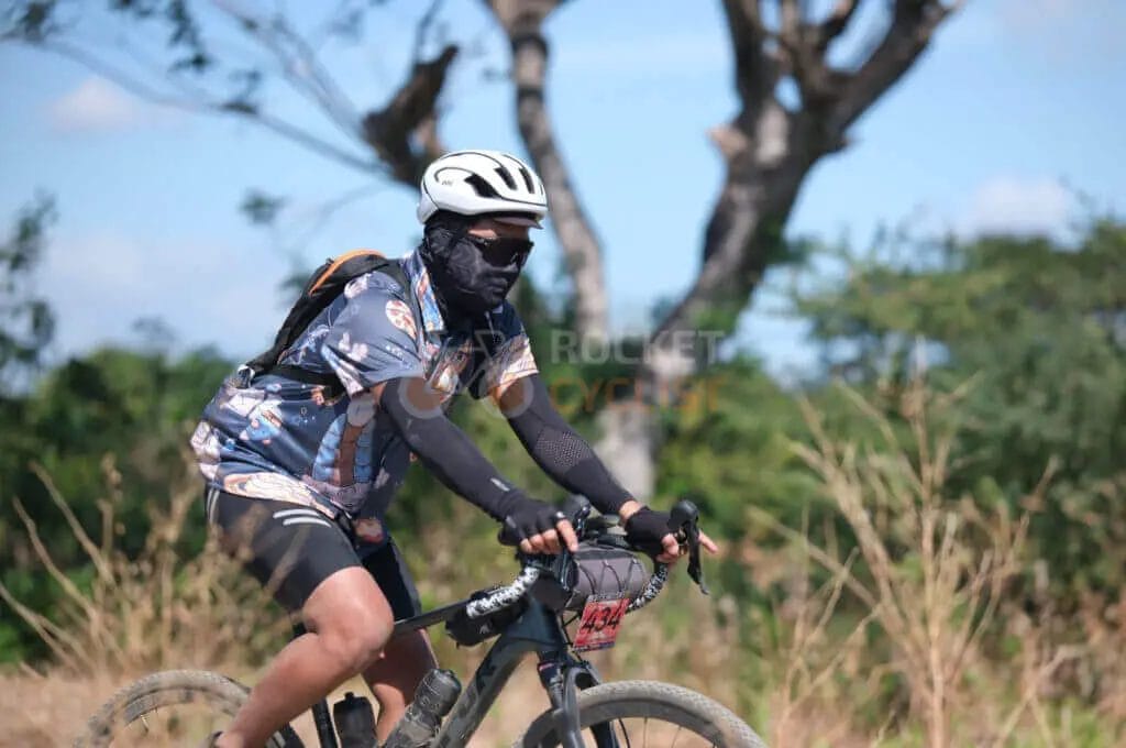 A man riding a bike through a field.