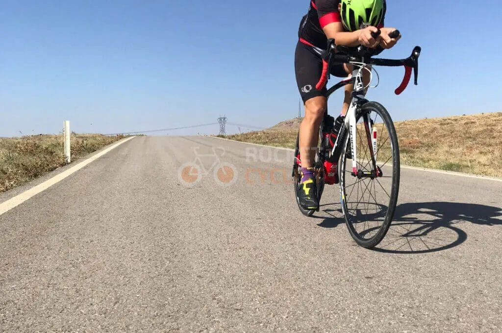 A man riding a bike down a country road.