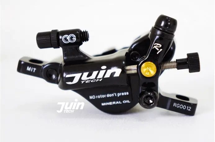 A bicycle brake caliper on a white surface.