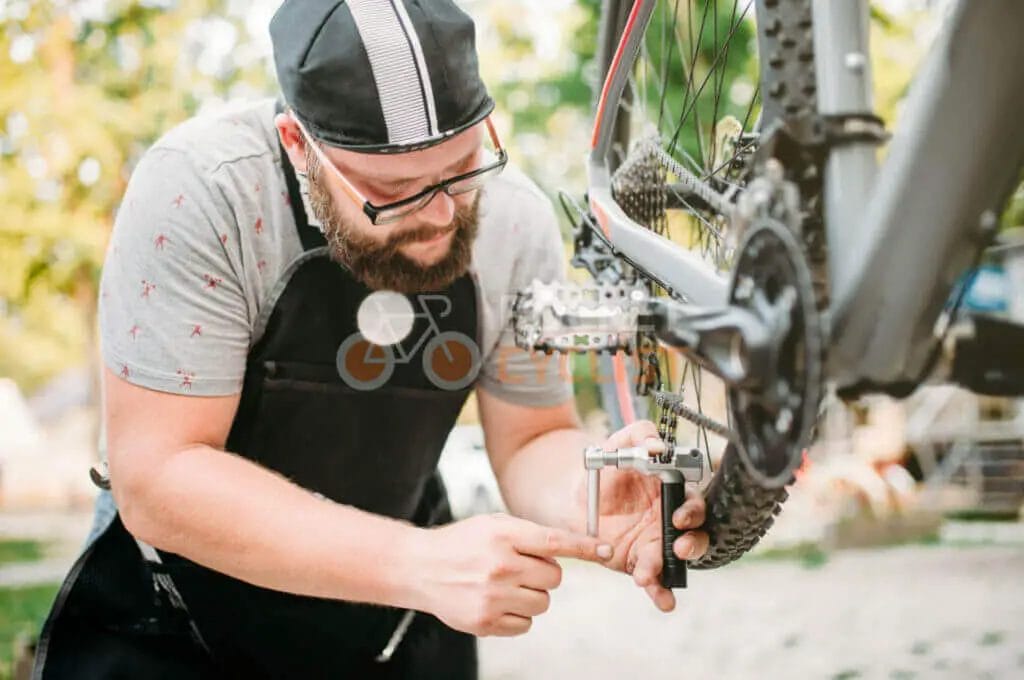 A bearded man is working on a bicycle.