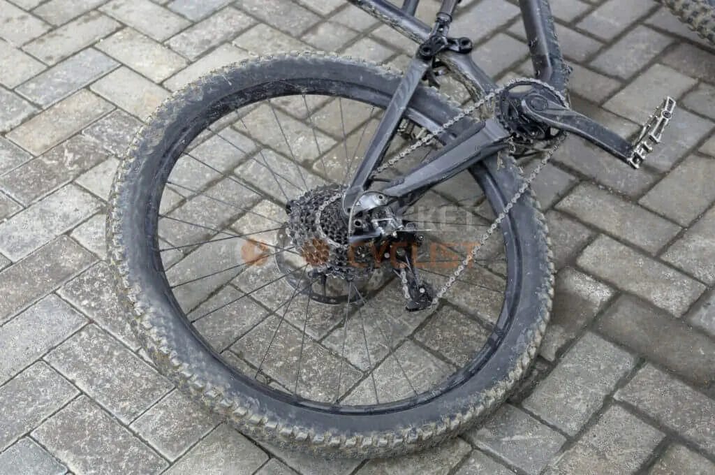 A mountain bike is leaning against a brick wall.