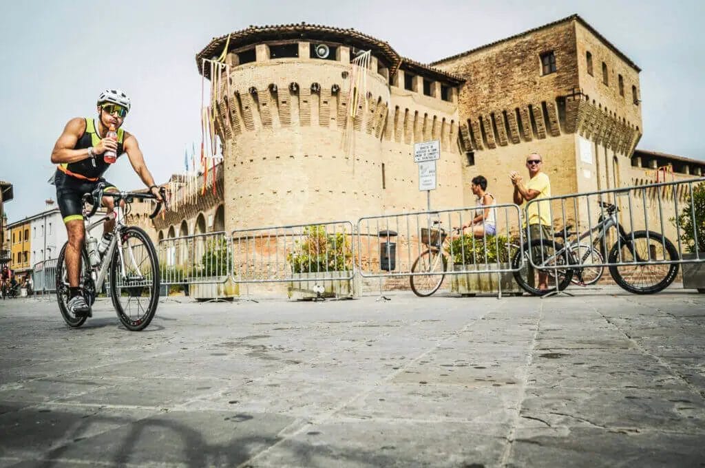 A man riding a bike in front of a castle.