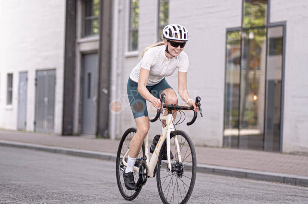 A woman riding a bike down a street.