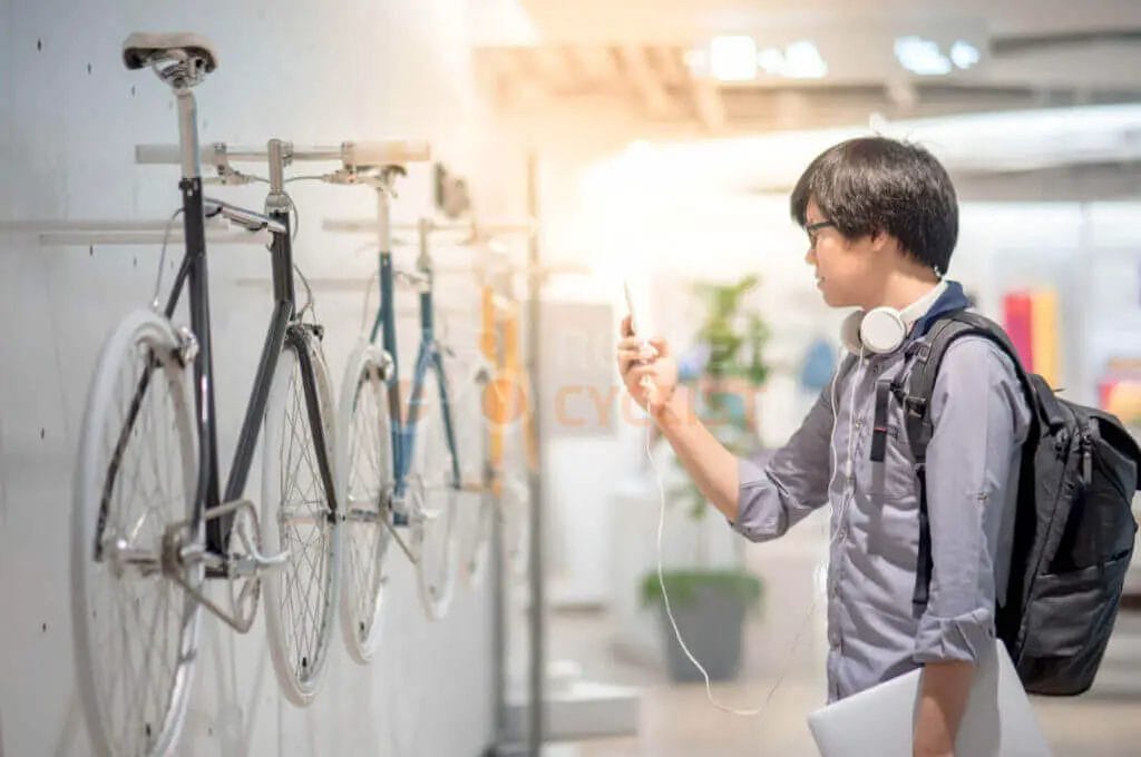 A young man looking at bicycles in a store.