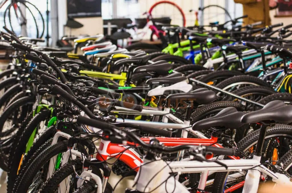 Many bicycles are lined up in a store.