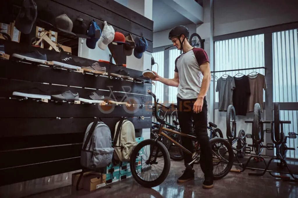 A man looking at his bike in a store.