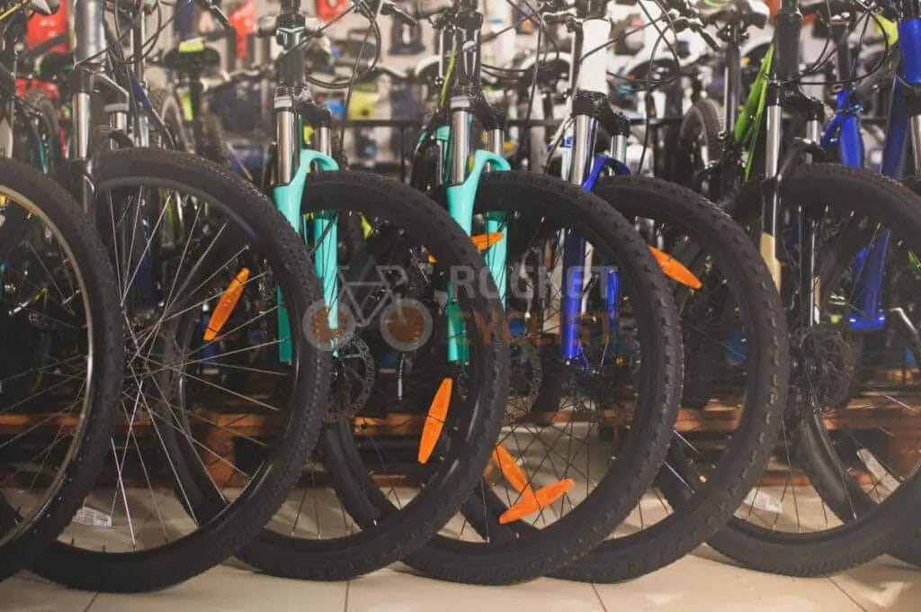 Many bicycles are lined up in a store.
