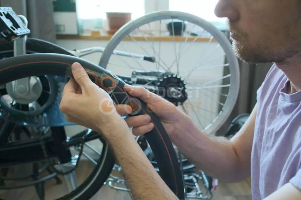 A man fixing a wheel on a wheelchair.