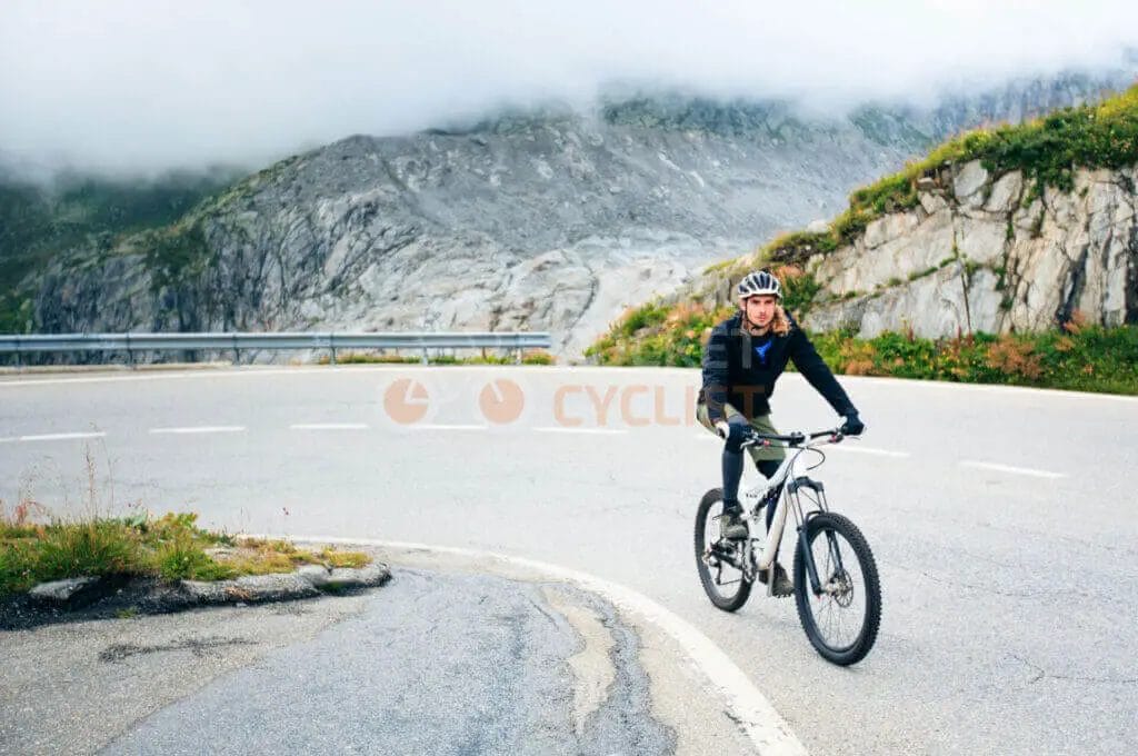 A woman riding a mountain bike on a mountain road.